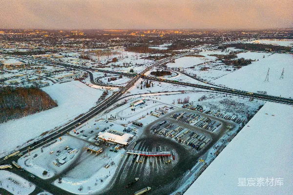 高清摄影 夕阳下的雪地高速公路互通鸟瞰图。