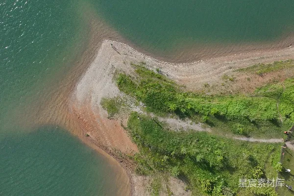 高清摄影 绿水与沙地、植被交织的陆地交汇。