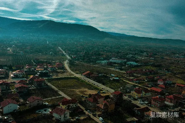 高清摄影 一座小镇的空中俯瞰图，背景是群山。
