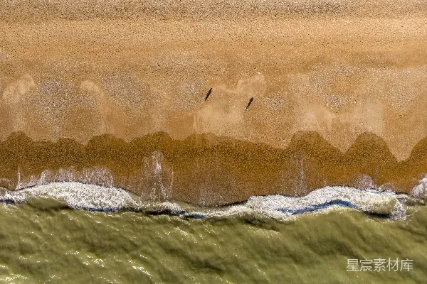 高清摄影 海滩的空中俯瞰图，海浪拍打着沙滩。