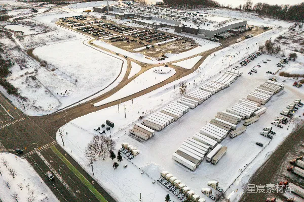高清摄影 雪地中的工业综合体航拍图，有卡车在行驶。