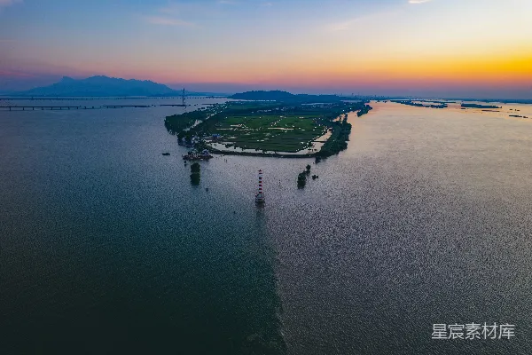 高清摄影 日落时分，灯塔矗立在平静水面上的小岛。