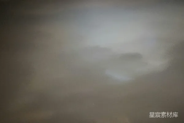 高清摄影 一张模糊的照片，显示的是多云的天空中阳光透过云层照射下来。