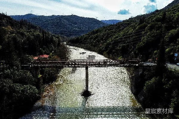 高清摄影 一座横跨河流的桥，周围环绕着群山。