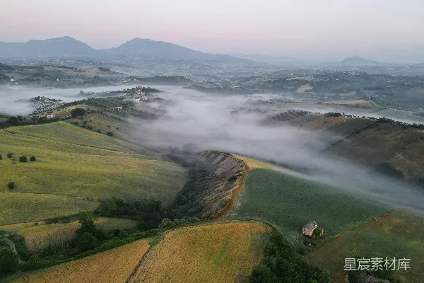 高清摄影 一片有着小山和远处水体的风景。