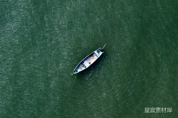 高清摄影 一艘小船漂浮在一片大水域上。