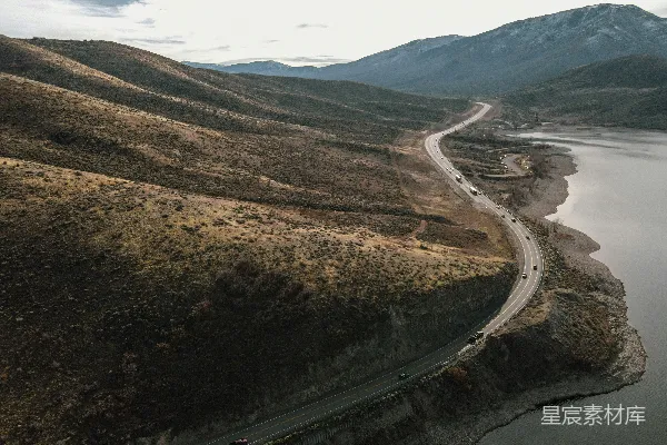 高清摄影 一条蜿蜒的道路俯瞰图，旁边是一片水域