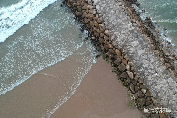 高清摄影 在海边有一堵石头墙，海浪正拍打着它。