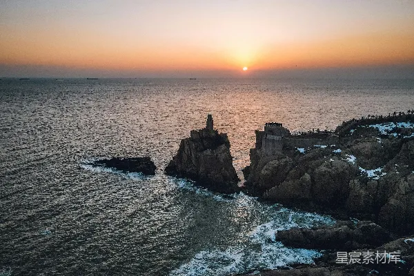高清摄影 太阳正落在这片岩石海岸附近的海面上。