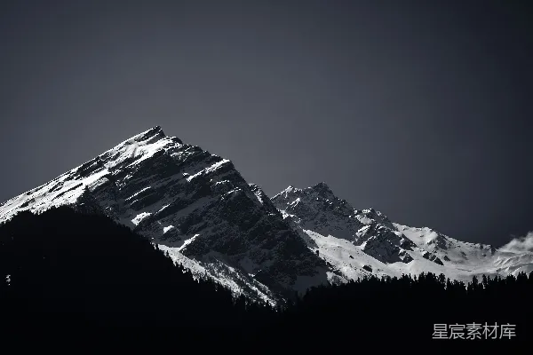 高清摄影 一张黑白照片，展示了一座被雪覆盖的山。