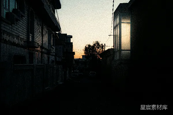 高清摄影 一条昏暗的小巷，两旁是建筑物和一个电话杆。