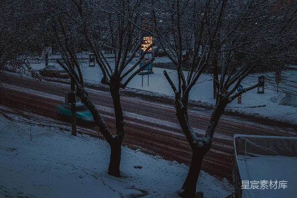 高清摄影 一条雪景中的街道，远处有一盏红绿灯。