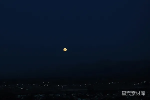 高清摄影 在城市的上空，一轮满月悬挂在天空中。