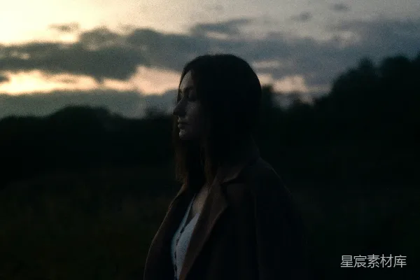 高清摄影 一个女人站在田野里，夕阳西下。