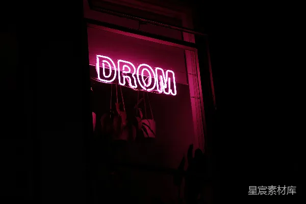 高清摄影 一盏霓虹灯，上面写着“drom”，挂在窗户上。