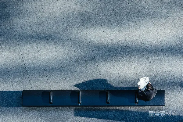 高清摄影 坐在黑色长凳上看报纸的人