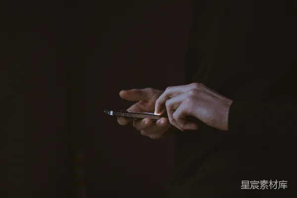 高清摄影 剪影照片，显示一个人手持智能手机。