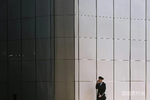 高清摄影 一个人在灰色建筑旁行走