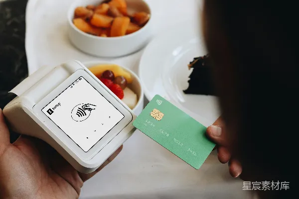 高清摄影 一个人拿着一张信用卡，旁边是一碗食物。
