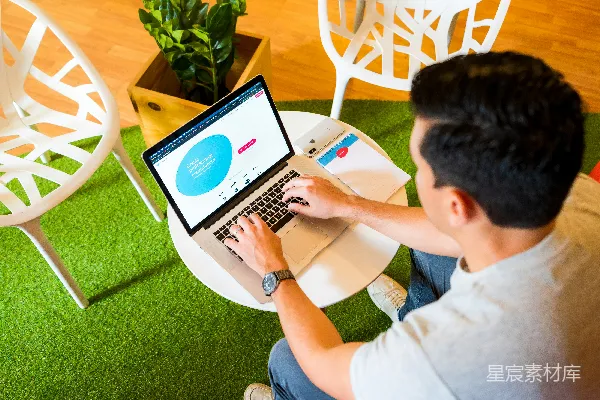 高清摄影 穿白色T恤的男孩在使用MacBook Pro