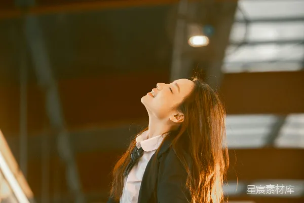 高清摄影 穿着职业装的年轻女子抬头开心地看着。