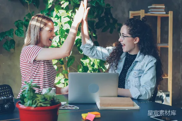 高清摄影 两位女士用高五庆祝成功。