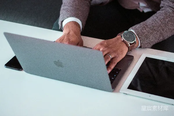 高清摄影 男人在iPad和iPhone之间使用MacBook