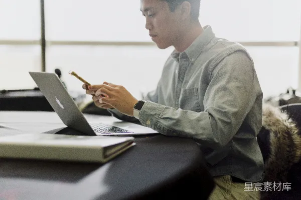 高清摄影 一个男人坐在笔记本电脑前。