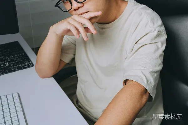 高清摄影 一名男子坐在桌前使用笔记本电脑。