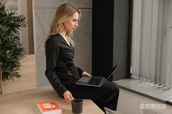 高清摄影 穿着黑色西装外套的女人使用MacBook Pro笔记本电脑