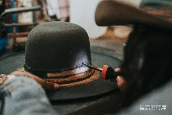 高清摄影 男人修理黑棕色的帽子