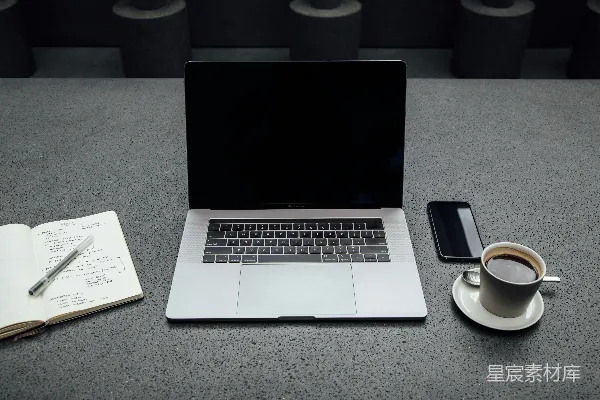 高清摄影 在咖啡杯、iPhone、笔记本和钢笔之间关闭的MacBook Pro