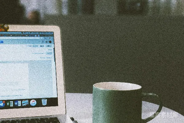 高清摄影 绿色的马克杯放在MacBook旁边。