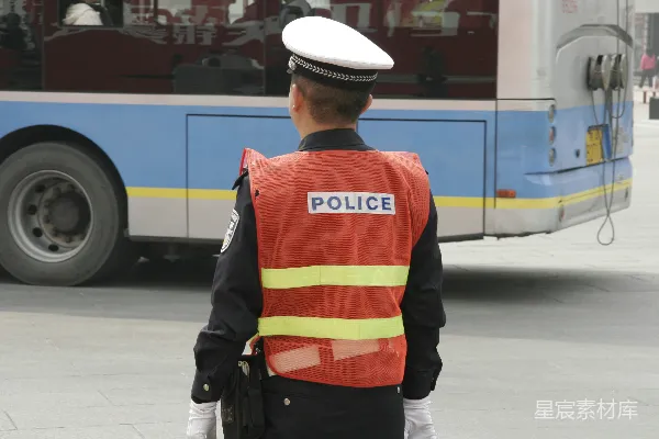 高清摄影 穿橙色和黑色夹克，戴着白色帽子的男人站在人行道上，白天。