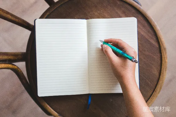 高清摄影 手拿蓝色点击笔的白色笔记本