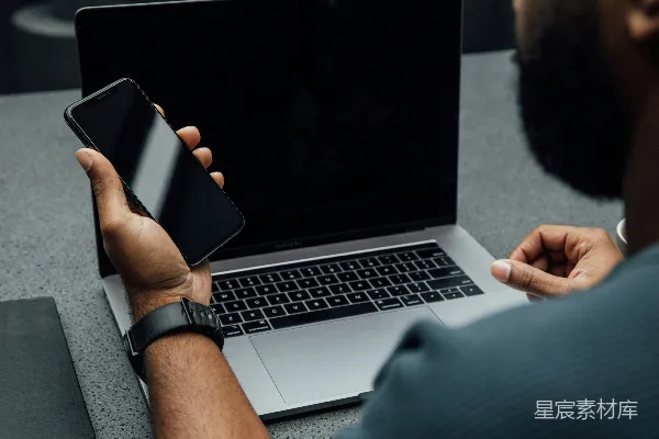 高清摄影 使用左手拿着iPhone靠近MacBook Pro的人