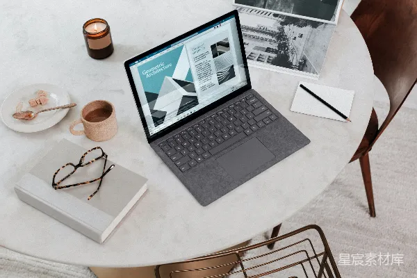 高清摄影 黑色笔记本电脑放在圆形桌子上，显示为Surface Laptop。