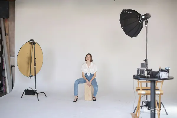 高清摄影 穿着白色T恤和蓝色牛仔短裤的女人坐在棕色木制座椅上。