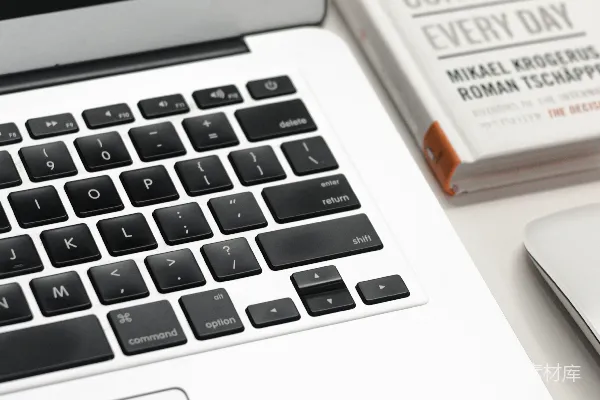 高清摄影 MacBook Air旁边有一个白色的Apple Magic Mouse。