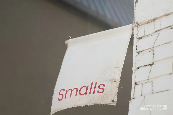 高清摄影 一个白色的“smalls”标志悬挂在砖柱上。
