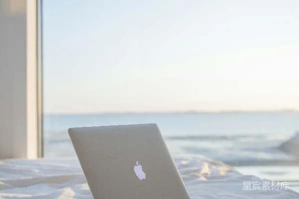 高清摄影 银色的MacBook放在白色床上