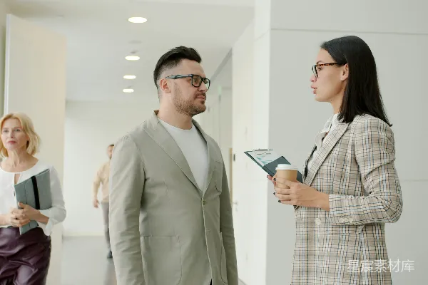 高清摄影 两个同事在现代办公室走廊里交谈。