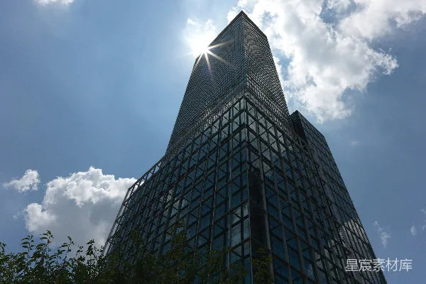 高清摄影 一座非常高大的建筑物，阳光透过云层照射进来。