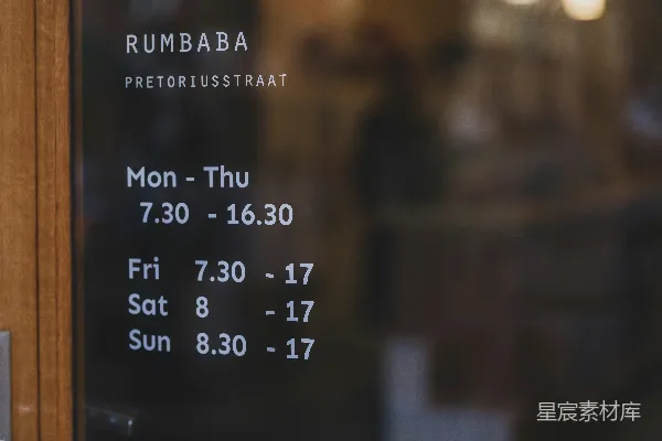 高清摄影 Rumbaba商店的营业时间显示在玻璃门上。