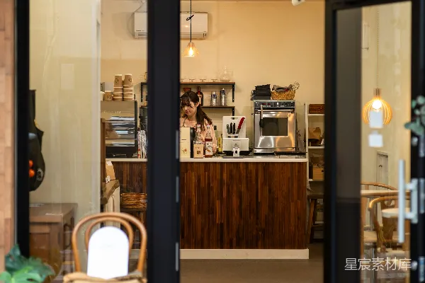 高清摄影 一家商店的门面，门口有一把椅子和盆栽植物。