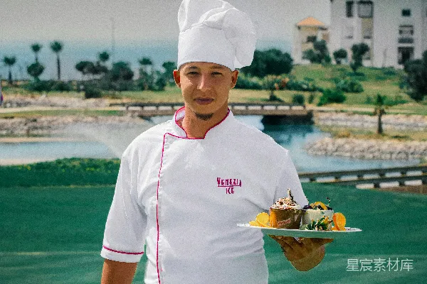 高清摄影 穿着白色厨师制服的女人拿着一个装有食物的绿色盘子。