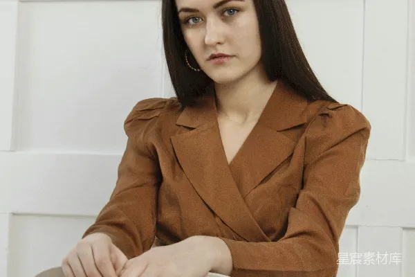 高清摄影 穿着棕色外套的女人坐在白色长凳上