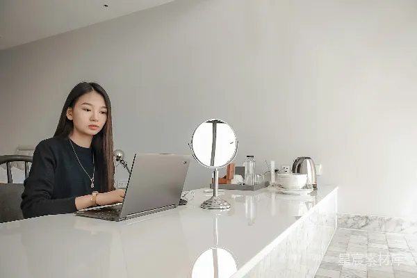 高清摄影 一个人坐在桌子旁使用笔记本电脑。