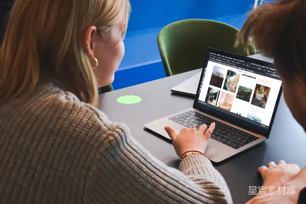 高清摄影 穿灰色毛衣的女人正在使用MacBook Pro。