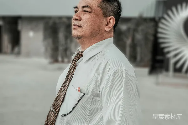 高清摄影 一位穿着衬衫和领带的男人站在一座建筑物前。